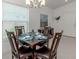 Dining room with dark wood furniture, tile floors and a modern chandelier at 12682 Shimmering Oak Cir, Venice, FL 34293