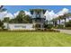 Community entrance featuring lush landscaping, a decorative tower, and the 'Grand Palm' sign at 12682 Shimmering Oak Cir, Venice, FL 34293