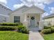 Inviting covered front porch featuring a light blue front door with a wreath and decorative landscaping at 12682 Shimmering Oak Cir, Venice, FL 34293