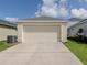 Detached garage with a paved driveway and neatly trimmed lawn, set against a blue sky at 12682 Shimmering Oak Cir, Venice, FL 34293