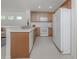 Spacious kitchen with white appliances, wood cabinets and a breakfast bar at 12682 Shimmering Oak Cir, Venice, FL 34293