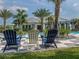 Clubhouse pool featuring three Adirondack chairs with palms and landscaping at 12682 Shimmering Oak Cir, Venice, FL 34293