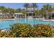 Beautiful community pool surrounded by palm trees, with a pool house and lounging areas at 12682 Shimmering Oak Cir, Venice, FL 34293