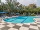 Community pool surrounded by mature trees and lounge chairs, perfect for relaxing at 12682 Shimmering Oak Cir, Venice, FL 34293