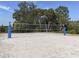 Outdoor sand volleyball court ready for a competitive match surrounded by mature trees at 12682 Shimmering Oak Cir, Venice, FL 34293