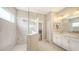 Modern bathroom featuring a glass-enclosed shower and a double vanity with white cabinetry at 12708 Aquamarine Ave, Bradenton, FL 34211