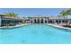 Community pool with ample seating, lush landscaping and inviting blue water at 12708 Aquamarine Ave, Bradenton, FL 34211