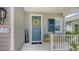 Inviting front porch featuring a vibrant blue door with a welcoming wreath and seating area at 12708 Aquamarine Ave, Bradenton, FL 34211