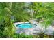 Relax in the hot tub surrounded by lush palm trees and tropical greenery at 12708 Aquamarine Ave, Bradenton, FL 34211