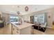 Open concept kitchen with island and dining area flows into a living room featuring large water view windows at 12708 Aquamarine Ave, Bradenton, FL 34211