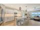 Bright, white kitchen with stainless appliances opens to living room with water view and wood flooring at 12708 Aquamarine Ave, Bradenton, FL 34211