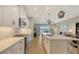 Open concept kitchen with island flows into a living room featuring large water view windows at 12708 Aquamarine Ave, Bradenton, FL 34211