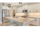Bright kitchen featuring white cabinets, stainless steel appliances, and a spacious quartz countertop island at 12708 Aquamarine Ave, Bradenton, FL 34211