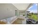 Outdoor patio area with modern rattan sectional, glass table, and hot tub, overlooking a scenic view at 12708 Aquamarine Ave, Bradenton, FL 34211