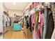 Spacious walk-in closet with extensive clothing racks, shelving and stylish turquoise cabinet for storage at 12708 Aquamarine Ave, Bradenton, FL 34211
