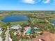 Scenic aerial view of the community pool, lake, and golf course at 13810 Messina Loop # 202, Bradenton, FL 34211