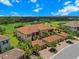 Aerial view of building with mature trees, lush landscaping, and lake views at 13810 Messina Loop # 202, Bradenton, FL 34211