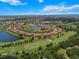 Aerial view of a home surrounded by a golf course with lush landscaping and lake at 13810 Messina Loop # 202, Bradenton, FL 34211