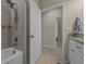 Cozy bathroom featuring shower, tile surround, and granite countertop with white cabinets at 13810 Messina Loop # 202, Bradenton, FL 34211