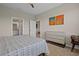 Well-lit bedroom showing two entryways, art on the walls and a comfortable bed with stylish linens at 13810 Messina Loop # 202, Bradenton, FL 34211