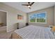 Comfortable bedroom with a large window and a view of the outdoors and a ceiling fan at 13810 Messina Loop # 202, Bradenton, FL 34211