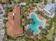 Aerial view of a sparkling community pool surrounded by palm trees and lounge chairs at 13810 Messina Loop # 202, Bradenton, FL 34211