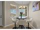 Bright dining area featuring a modern round table with stylish chairs, illuminated by a chandelier, bathed in natural light at 13810 Messina Loop # 202, Bradenton, FL 34211