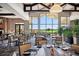 A dining room overlooking the golf course with tables for four and large windows at 13810 Messina Loop # 202, Bradenton, FL 34211