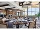 A dining room featuring large windows, tables for four, and decorative pendant lighting at 13810 Messina Loop # 202, Bradenton, FL 34211