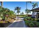 Paver pathway leading to an event lawn, lined with lush tropical landscaping and palm trees at 13810 Messina Loop # 202, Bradenton, FL 34211
