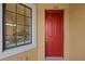 Charming condo entrance with a vibrant red door, window with blinds, and the unit number 202 at 13810 Messina Loop # 202, Bradenton, FL 34211