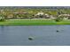 Scenic golf course view with floating greens in a lake, surrounded by lush landscaping and tropical trees at 13810 Messina Loop # 202, Bradenton, FL 34211