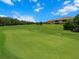Scenic golf course view with lush green grass and trees under a bright blue sky at 13810 Messina Loop # 202, Bradenton, FL 34211