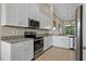 Modern white kitchen with stainless steel appliances, granite countertops and ample cabinet space at 13810 Messina Loop # 202, Bradenton, FL 34211