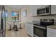 Modern eat-in kitchen features stainless appliances, granite countertops, and a round breakfast table at 13810 Messina Loop # 202, Bradenton, FL 34211