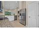Open-concept kitchen with stainless steel appliances and granite countertops flowing to living area at 13810 Messina Loop # 202, Bradenton, FL 34211