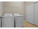 Bright laundry room featuring a washer, dryer, storage shelf, and closet at 13810 Messina Loop # 202, Bradenton, FL 34211