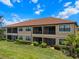 Two-story building with screened lanais and lush landscaping in the rear at 13810 Messina Loop # 202, Bradenton, FL 34211