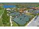 Aerial view showcasing well-maintained tennis courts, a pool, and surrounding community amenities at 13810 Messina Loop # 202, Bradenton, FL 34211