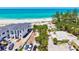 Aerial view showcases a modern home near a sandy beach, with blue water and lush palm trees at 145 50Th St, Holmes Beach, FL 34217