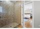 Bathroom shower with tan tile and glass door leading to the main bedroom at 145 50Th St, Holmes Beach, FL 34217