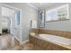 Bathroom with a soaker tub, seahorse art and natural light from the window at 145 50Th St, Holmes Beach, FL 34217