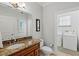 Bathroom featuring a dark wood vanity, toilet, and a laundry area at 145 50Th St, Holmes Beach, FL 34217