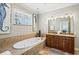 Luxurious bathroom featuring a soaking tub, double vanity, and beach-inspired decorations at 145 50Th St, Holmes Beach, FL 34217