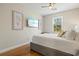 Comfortable bedroom with light walls, wood floor, ceiling fan and flatscreen TV at 145 50Th St, Holmes Beach, FL 34217
