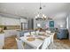 An open-concept dining room with white table setting is next to the kitchen at 145 50Th St, Holmes Beach, FL 34217