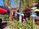 Outdoor dining area with a tropical theme, lush greenery and pink flamingos, creating a fun atmosphere at 145 50Th St, Holmes Beach, FL 34217