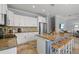 Spacious kitchen island with bar seating and a view of the adjacent living area and staircase at 145 50Th St, Holmes Beach, FL 34217