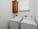 Laundry room featuring a newer washer and dryer with overhead cabinet at 145 50Th St, Holmes Beach, FL 34217