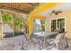Outdoor patio with a ceiling fan, covered area, table, and access to a staircase surrounded by lush tropical plants at 145 50Th St, Holmes Beach, FL 34217